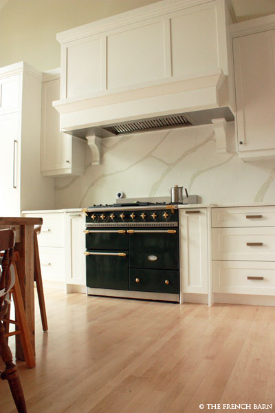 Green stove with cream cabinetry